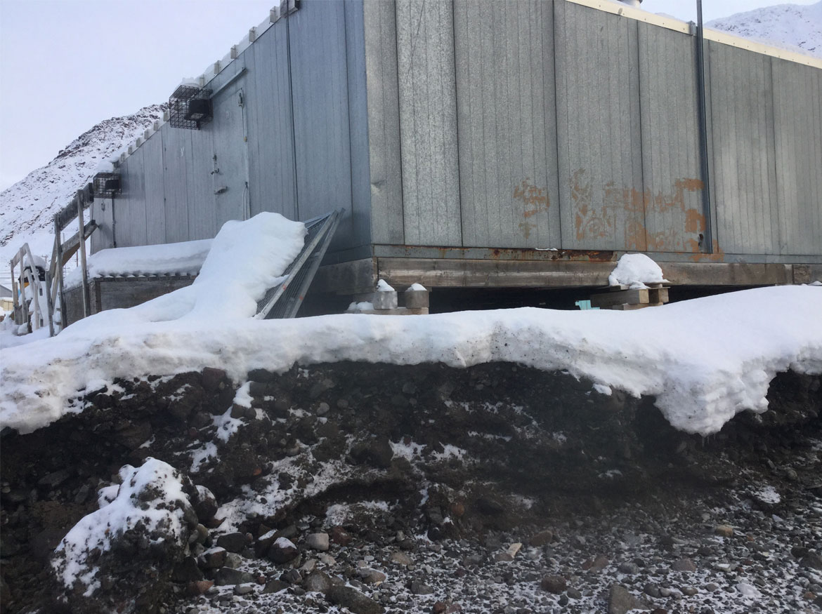 Gros plan de la fondation d’un bâtiment sur un terrain qui s’érode.