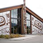 Façade du bâtiment en bois décorée de peintures typiques de l'art de la côte nord-ouest du Pacifique.