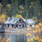 Cabane en bois, abîmée par le temps, au bord de la rivière. 