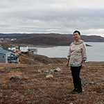 Leena standing outside in front of the ocean in Iqaluit.