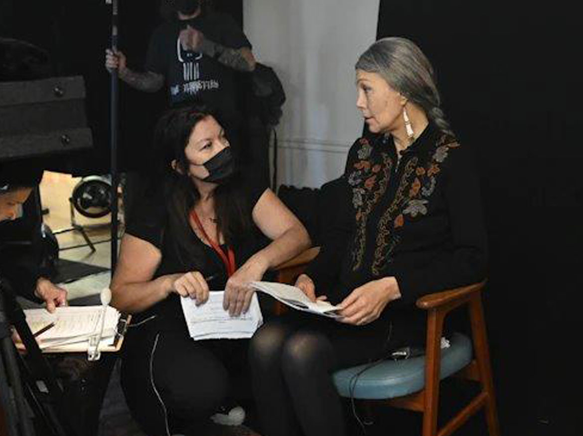 Director Marie Clements talking with an actor on set.
